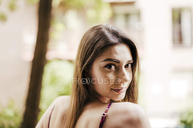 Mulher bonita olhando sobre o ombro ao ar livre — Fotografia de Stock