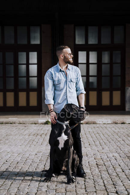Hombre y su perro mirando a la distancia - foto de stock