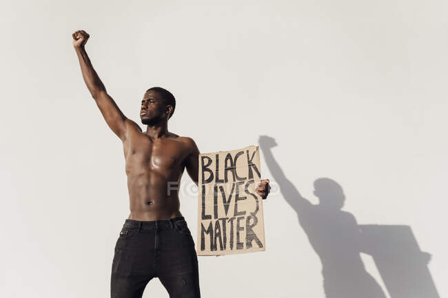 Homme noir levant le poing, tenant Black Lives Matter signe — Photo de stock