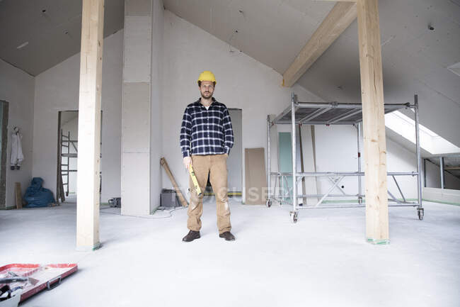 Confident construction worker standing at renovating home — Stock Photo