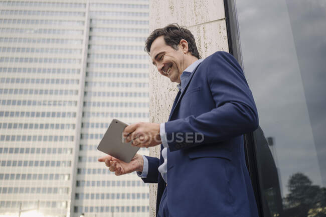 Heureux homme d'affaires mature en utilisant la tablette dans la ville — Photo de stock