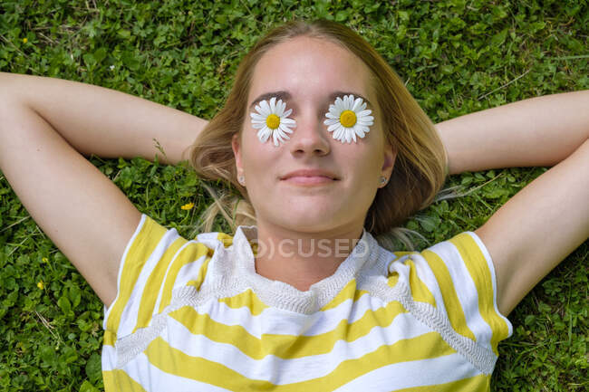 Gros plan d'une jeune femme avec des marguerites aux yeux de bœuf sur des terrains herbeux dans un parc — Photo de stock