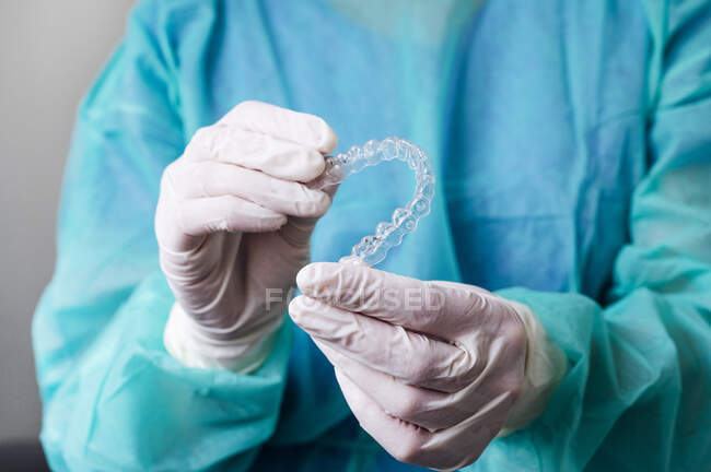 Close-up de dentista segurando alinhadores dentários em forma de coração na clínica — Fotografia de Stock