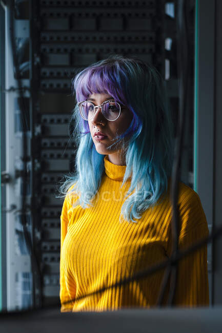 Close-up of thoughtful young woman with dyed hair and piercings in old office — Stock Photo
