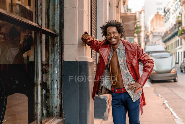 Happy retro man wearing leather jacket while standing on sidewalk in city — Stock Photo