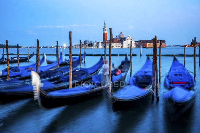 Italia, Veneto, Venezia, Gondole ormeggiate in marina al tramonto con San Giorgio Maggiore sullo sfondo — Foto stock