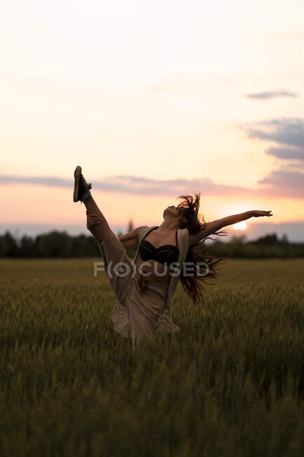 Donna che balla sul campo durante il tramonto — Foto stock