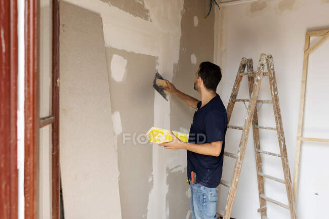 Construction worker plastering wall in a house — Stock Photo