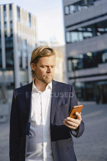 Uomo d'affari che utilizza smartphone in città — Foto stock