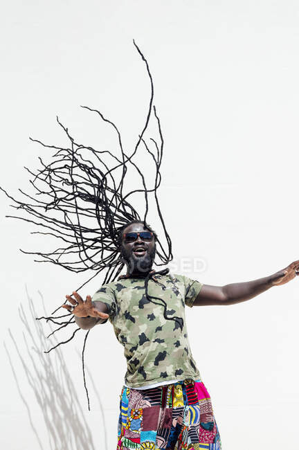 Rastafari man with sunglsasses tossing his dreadlocks — Stock Photo