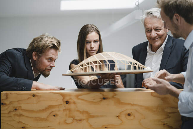 Gente de negocios exitosa mirando el modelo arquitectónico en la oficina - foto de stock