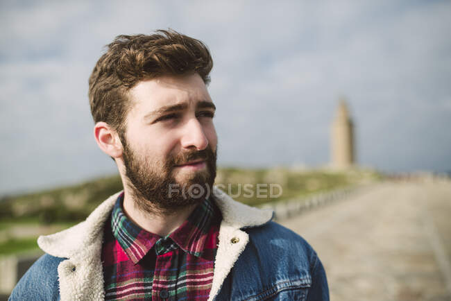 Close-up of thoughtful bearded man looking away against cloudy sky — Stock Photo