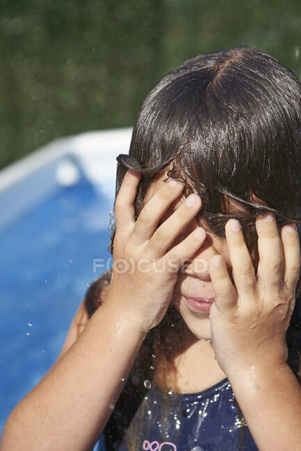 Primer plano de chica mojada frotando los ojos en el patio - foto de stock