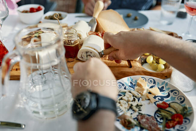Amici che cenano con un piatto di formaggio — Foto stock