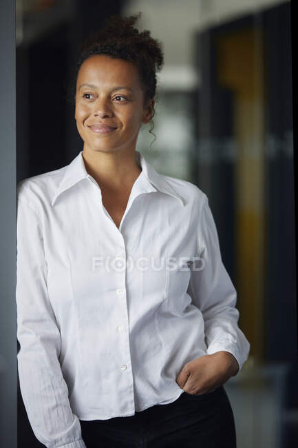 Portrait d'une femme d'affaires confiante penchée à la porte au bureau — Photo de stock