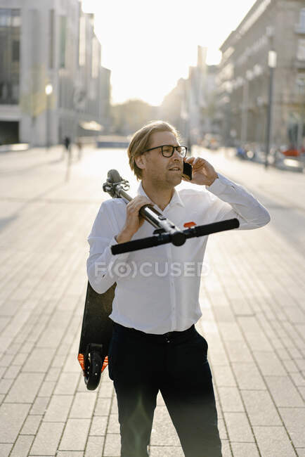 Бізнесмен з коляскою по телефону в місті. — стокове фото