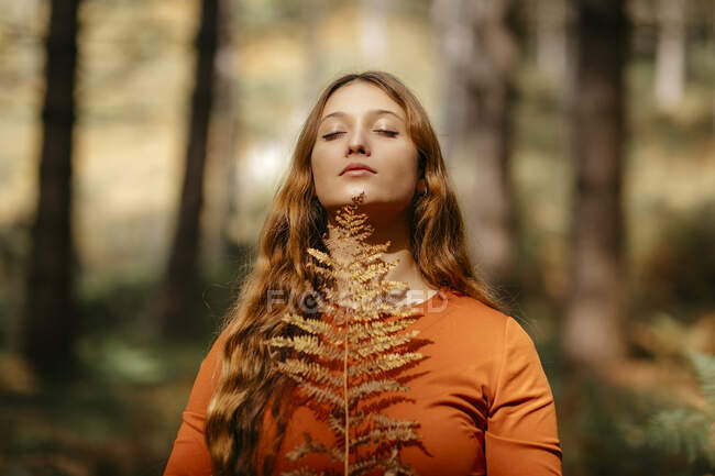 Primo piano di bella donna con lunghi capelli biondi in piedi nel bosco — Foto stock