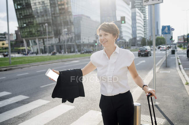 Улыбающаяся деловая женщина, стоящая на улице в городе — стоковое фото