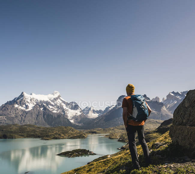 Man with backpack looking at lake against clear sky, Torres Del Paine National Park, Patagonia, Chile — Stock Photo