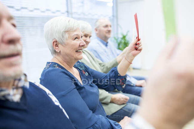 Anziani in casa di riposo frequentano terapia di gruppo utilizzando carte di carta colorate — Foto stock