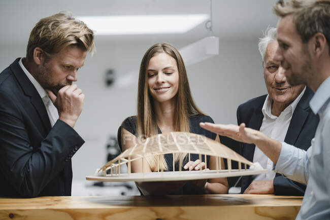 Successful business people looking at architectural model in office — Stock Photo