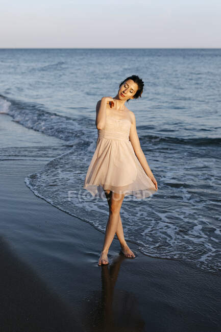 Delicate ballerina dancing on the beach at sunset — Photo de stock
