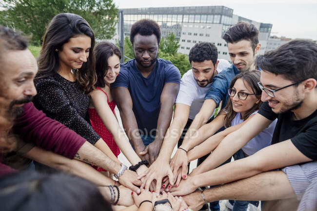 Ami masculin et féminin ludique empilant les mains tout en se tenant dans le parc — Photo de stock