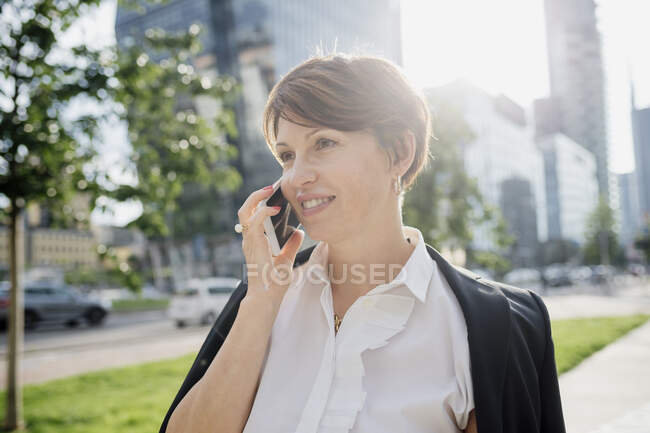 Close-up of businesswoman with short hair talking over smart phone in city — Fotografia de Stock