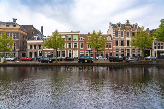 Paesi Bassi, Olanda Settentrionale, Haarlem, Auto parcheggiate e case storiche lungo il canale di Binnen Sparne — Foto stock