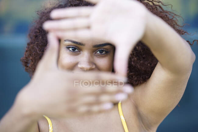 Gros plan de la jeune femme faisant cadre doigt — Photo de stock