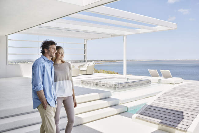 Casal na casa de praia de luxo desfrutando de vista — Fotografia de Stock
