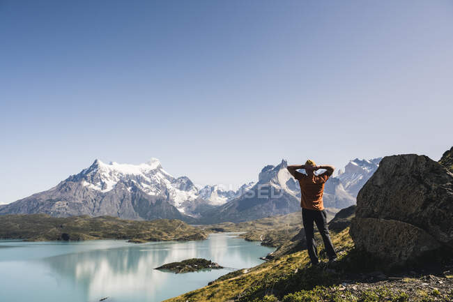 Людина стоїть біля озера проти чистого неба в національному парку Торрес - Дель - Пейн (Патагонія, Чилі). — стокове фото