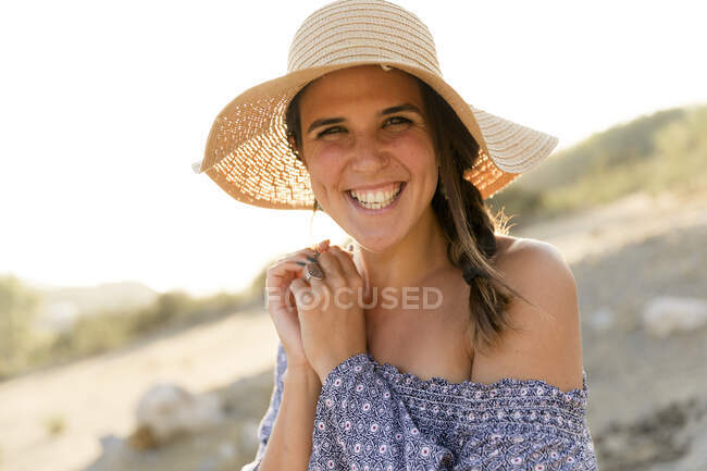 Joyeux jeune femme portant un chapeau de soleil pendant la journée ensoleillée — Photo de stock