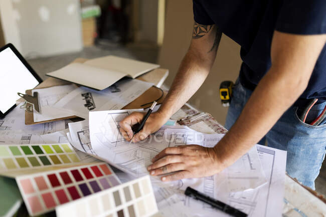 Hombre trabajando en el plan de construcción y la muestra de color - foto de stock