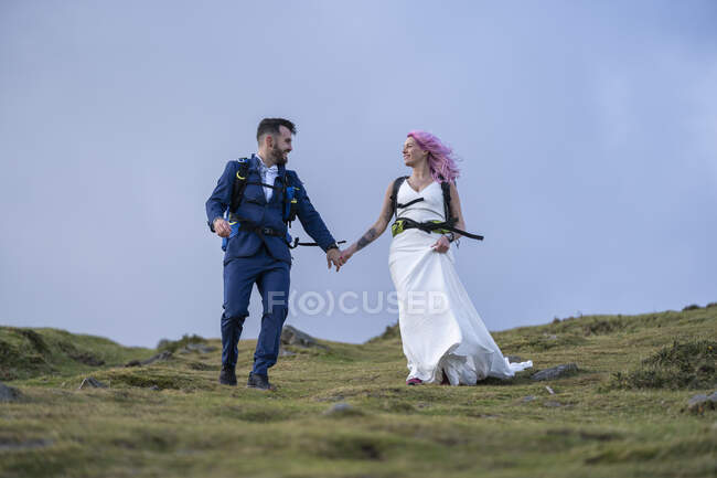 Couple nuptial avec sacs à dos d'escalade à Urkiola montagne, Espagne — Photo de stock