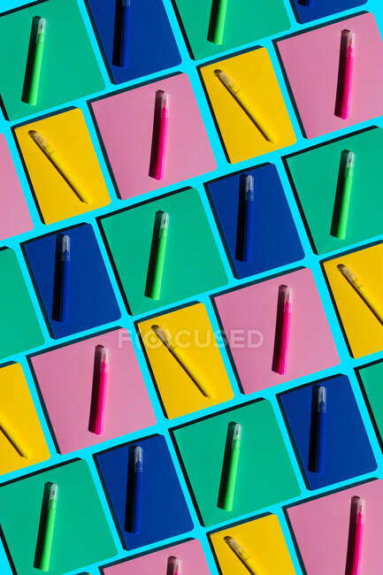 Pattern of colorful notebooks and matching felt tip pens — Stock Photo