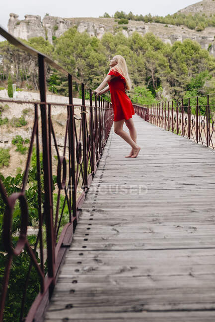 Woman wearing red dress on Saint Paul Bridge in Cuenca, Spain — Stock Photo
