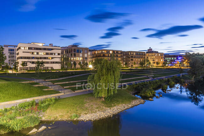Alemanha, Baden-Wrttemberg, Heilbronn, Neckar, distrito de Neckarbogen, Novos edifícios de apartamentos energeticamente eficientes iluminados ao entardecer — Fotografia de Stock