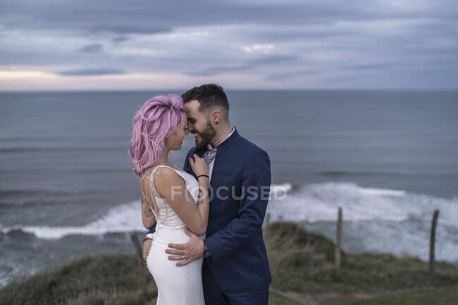 Свадебная пара на смотровой площадке и океан на заднем плане — стоковое фото