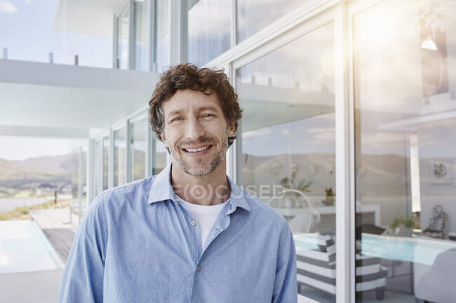 Retrato de un hombre confiado en una casa de playa de lujo - foto de stock