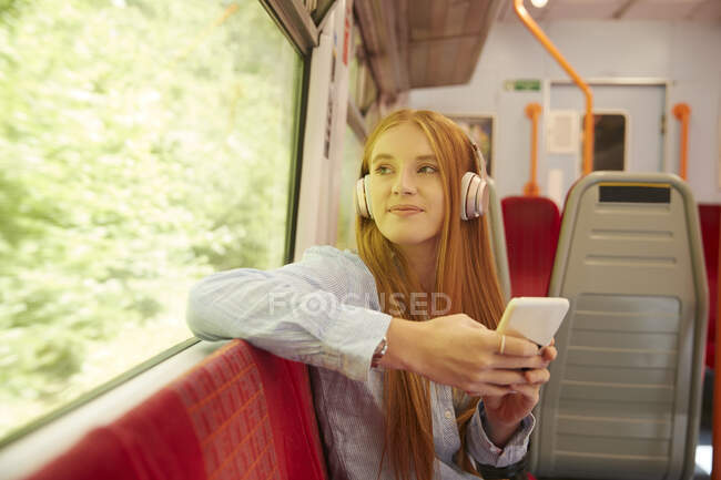 Beautiful woman listening music while sitting in train — Photo de stock