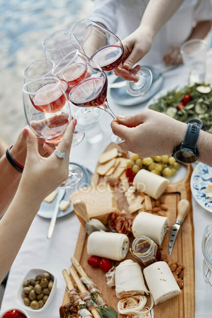 Amis dîner dans un lac cliquetis verres à vin — Photo de stock