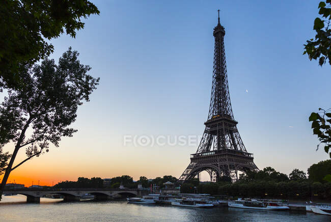 Tour Eiffel au bord de la seine face au ciel dégagé au coucher du soleil, Paris, France — Photo de stock