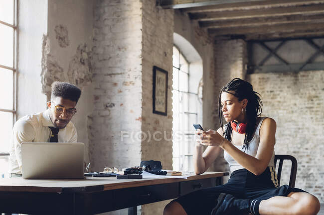 Creative business people working at table in loft office — Stock Photo