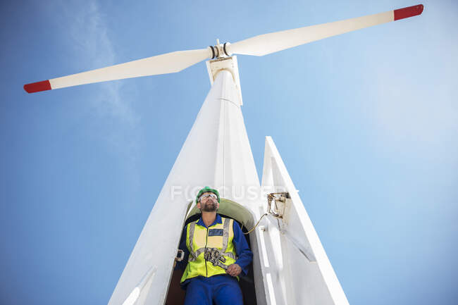 Ingeniero inspeccionando turbina eólica, usando llave inglesa - foto de stock