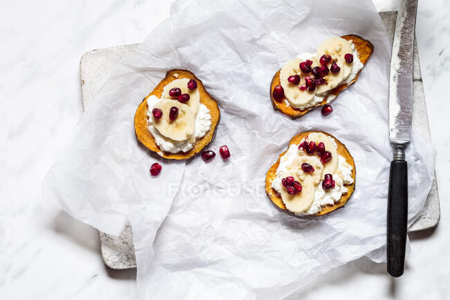 Toasted slices of sweet potato with cottage cheese, banana and pomegranate seeds — Stock Photo