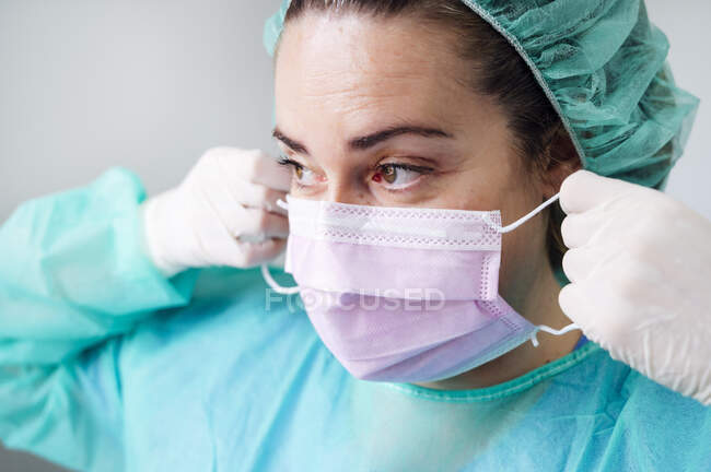 Зблизька медсестра у хірургічній масці, яка дивиться у клініці. — стокове фото