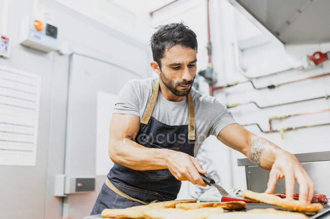 Panadero con pan horneado en la panadería - foto de stock