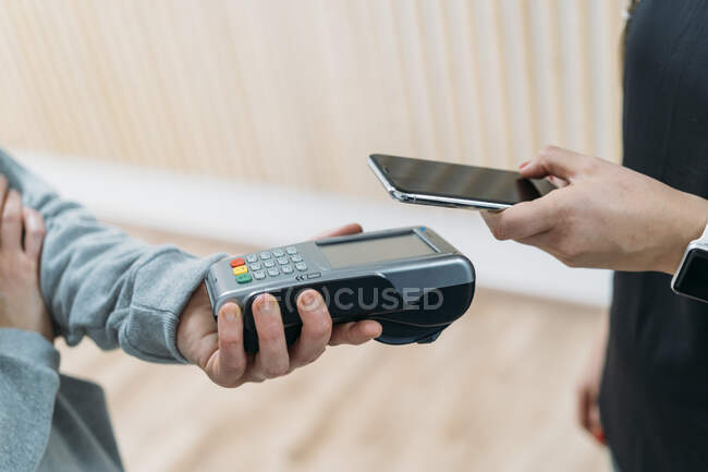 Paying cashless with smartphone at health club — Stock Photo