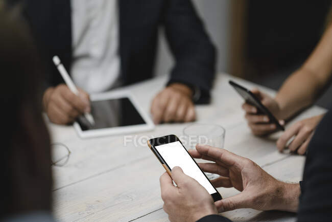 Business people working in office using portable devices, close up — Stock Photo